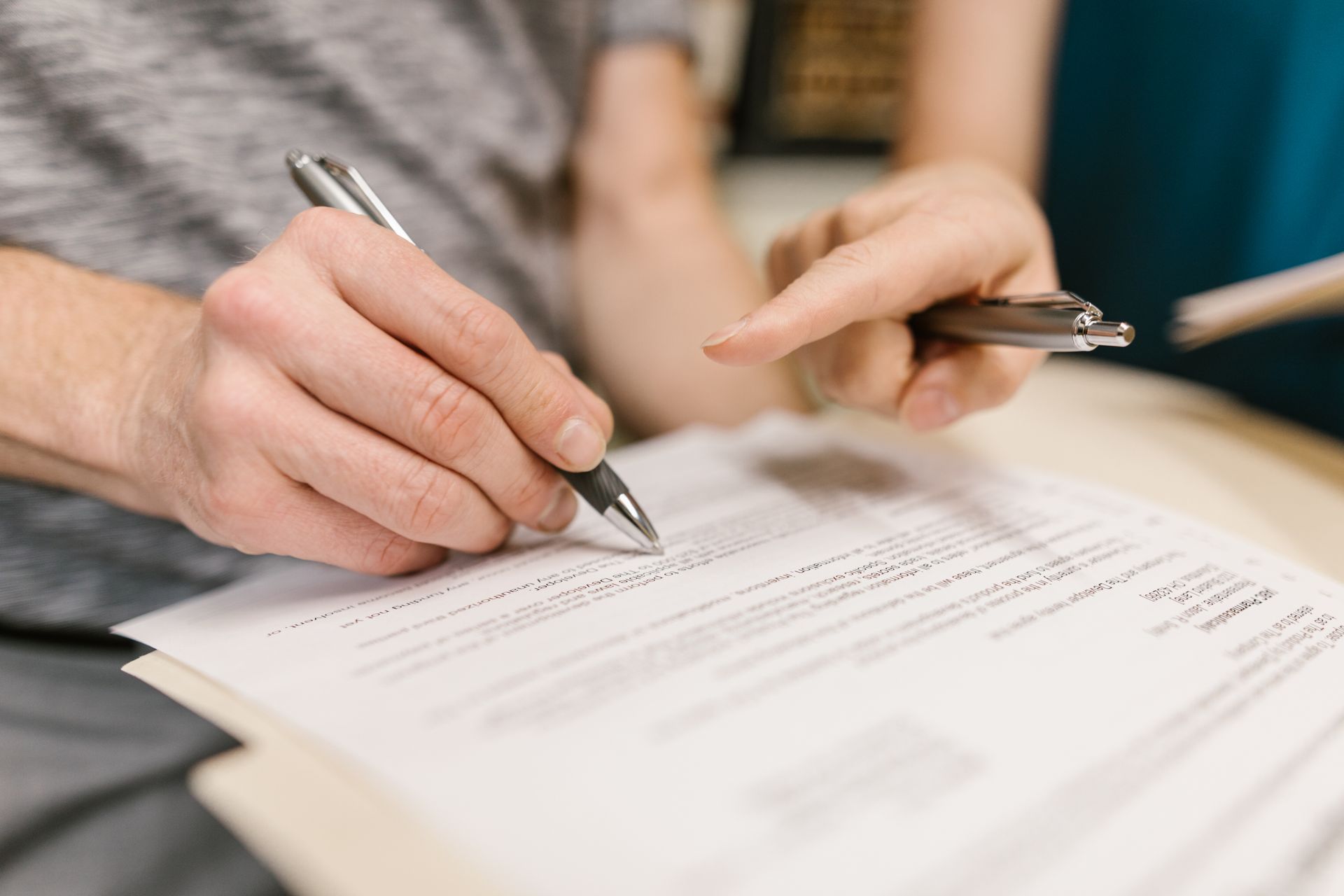 People reviewing and signing a legal document relating to a deed of variation and inheritance